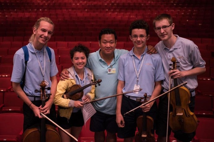 Valade Concertmaster Dennis Kim poses with Camp students.
