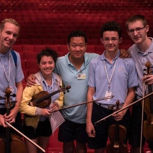 Valade Concertmaster Dennis Kim poses with Camp students.