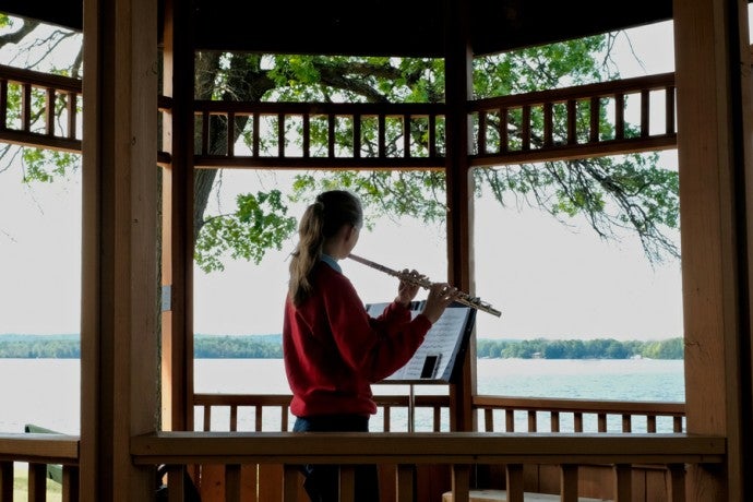 A student practices flute in a gazebo at Interlochen Arts Camp. 