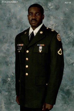 A man poses in a military uniform