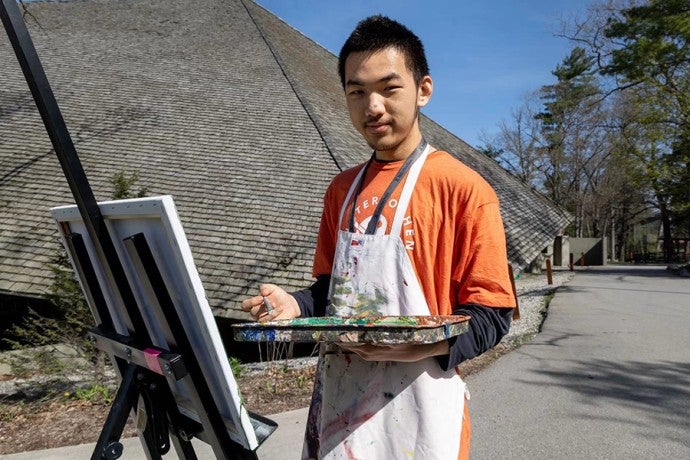 Bradom Zhang paints outside of Kresge Auditorium during the annual Run for the Arts 5K in May 2024.