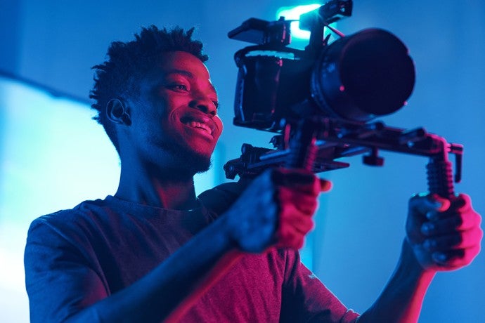 A student operates a video camera.