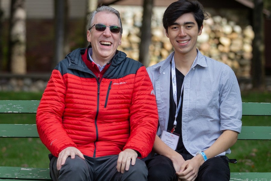 Two men on a green bench