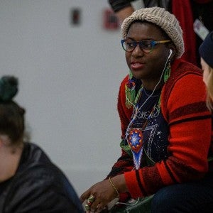 Kenyatta Hinkle (center) chats with Instructor of Visual Arts Megan Hildebrandt (right) while the students work.