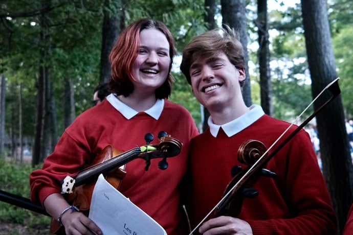 Two students share a smile before the summer 2023 performance of "Les Préludes."