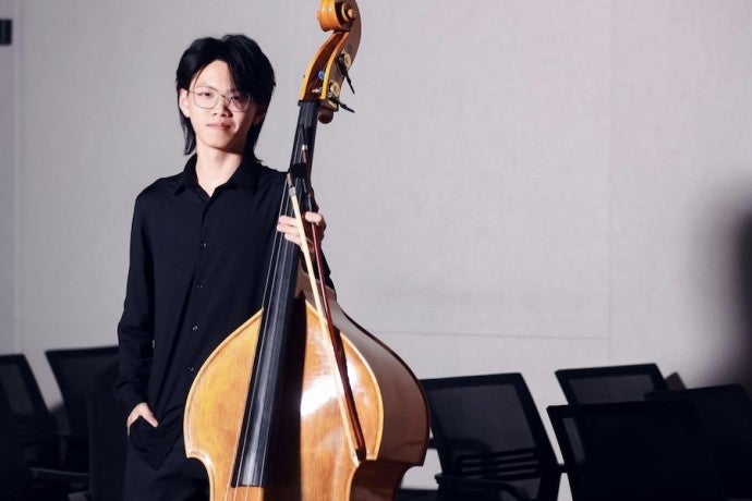 A student poses with a double bass.