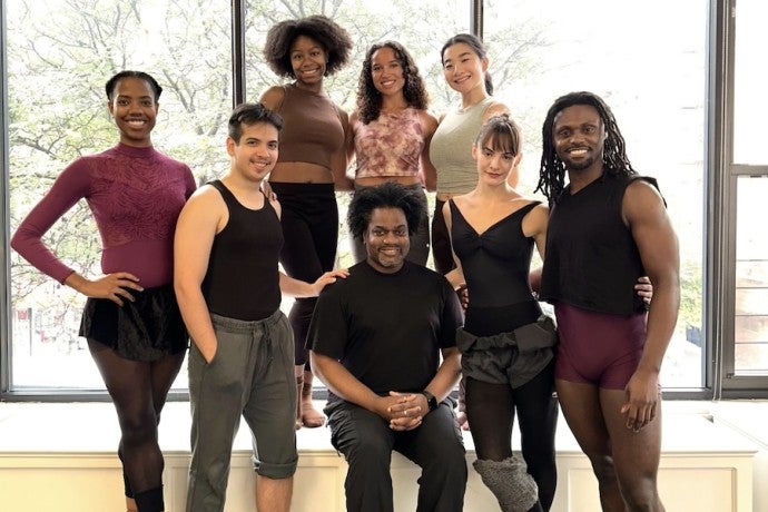 A group of dancers pose with their artistic director. 