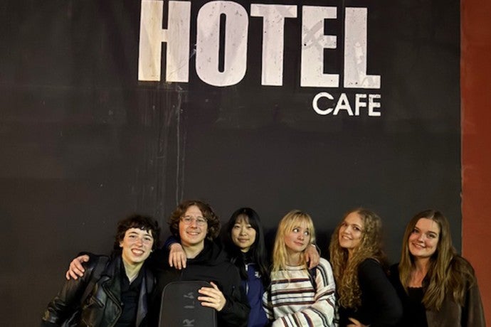 Interlochen Arts Academy singer-songwriter students pose in front of the Hotel Cafe sign.