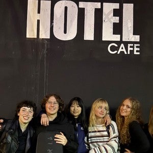 Interlochen Arts Academy singer-songwriter students pose in front of the Hotel Cafe sign.