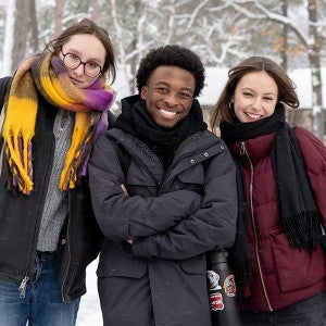 Three Interlochen Arts Academy students pause for a picture on a snowy day.